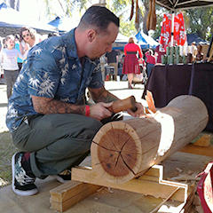 Tiki Dylan carving a tiki at GreazeFest